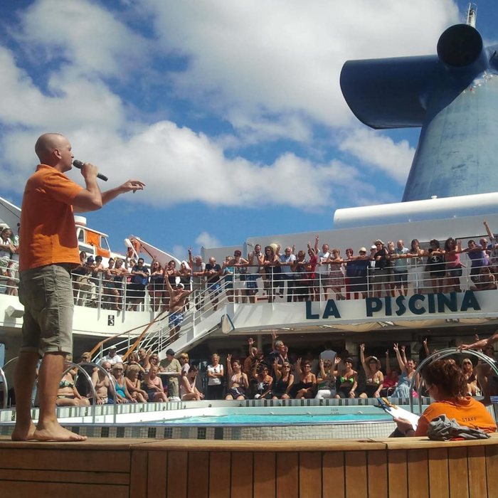 David hosting a show on the pool deck, with passengers cheering