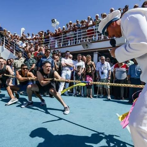 David in uniform running a tug of war on deck