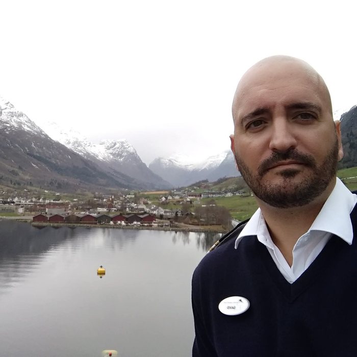 David in uniform with a snow-covered fjord behind him