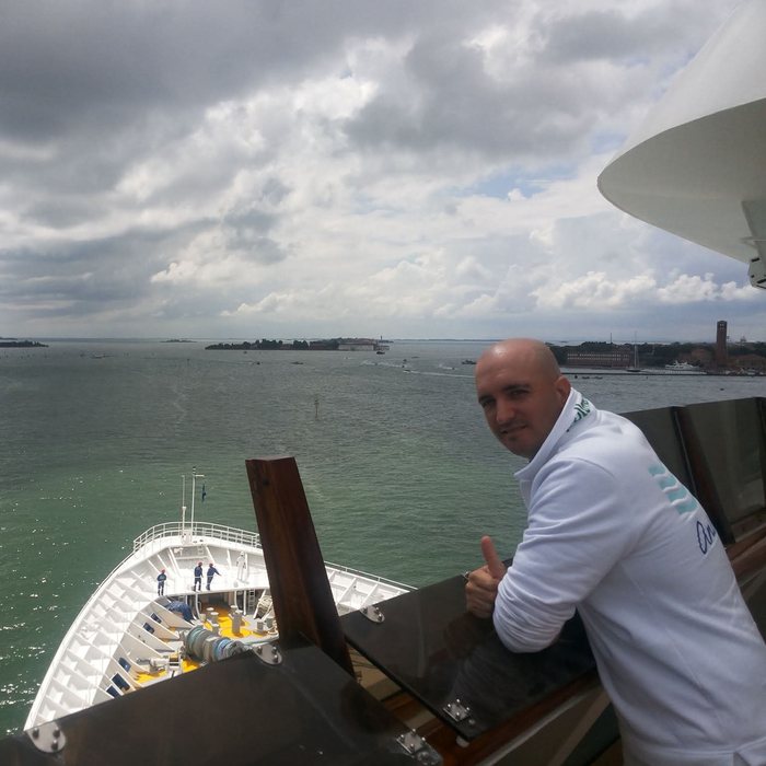 David on deck with the bow and the coast behind him